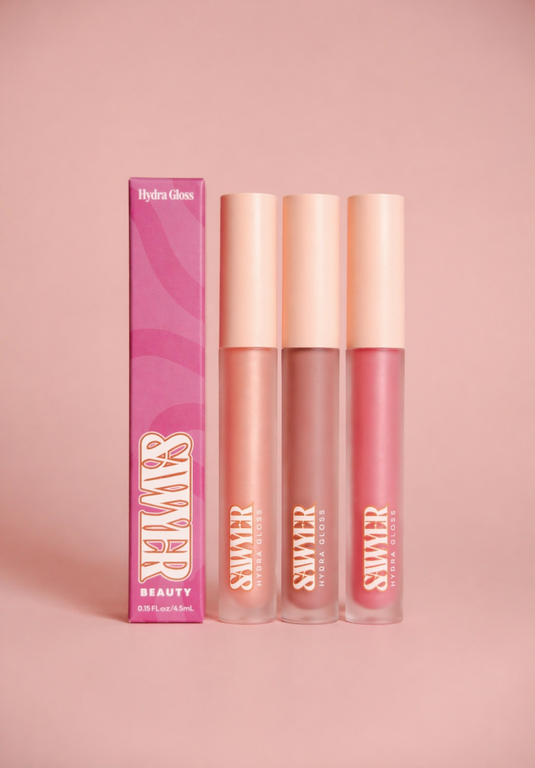 Three lip glosses with a pink box on a pink background